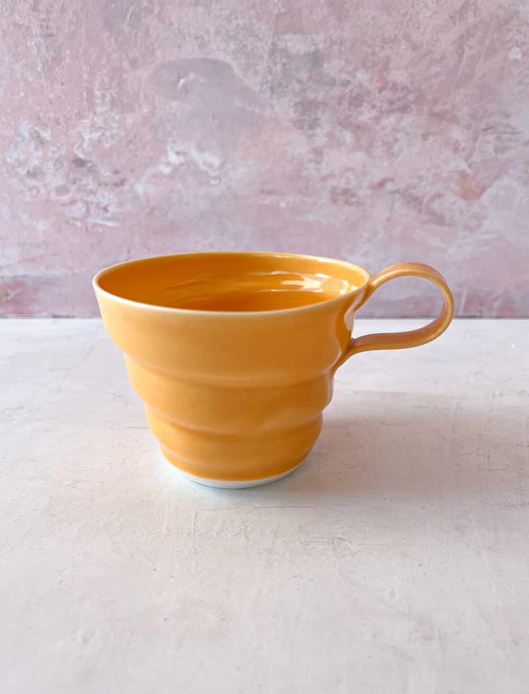 rikke mangelsen keramik, porcelæns kop i orange, kaffe kop, kop, pastelfarvet kop, kaffekop, tekop, håndlavet keramik, kopper med hank, made in denmark, dansk design, remix by sofie, bordækning